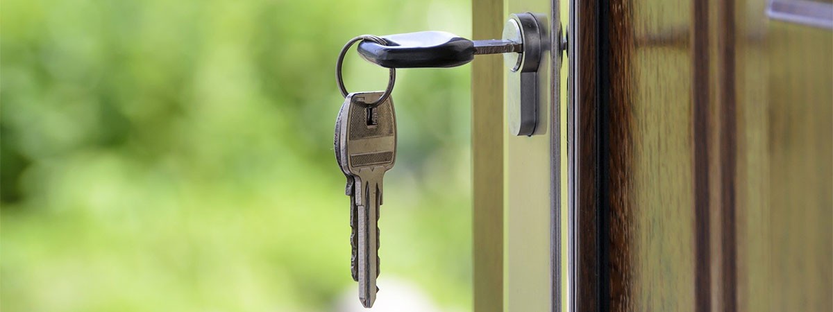Ein Schlüssel steckt in einer offenen Haustür eines Zuhauses.