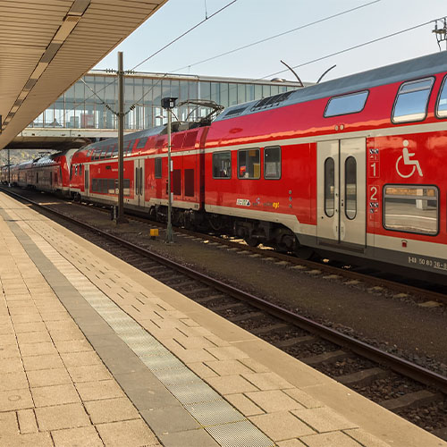 Ein schwarzes Spielzeug-Auto steht auf Stapeln aus Euro-Münzen. Das Vorderteil des Autos steht auf einem niedrigeren Stapel. Dadurch neigt sich das Auto nach unten.