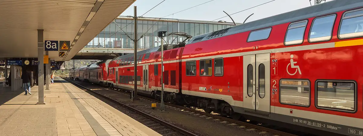 Ein schwarzes Spielzeug-Auto steht auf Stapeln aus Euro-Münzen. Das Vorderteil des Autos steht auf einem niedrigeren Stapel. Dadurch neigt sich das Auto nach unten.