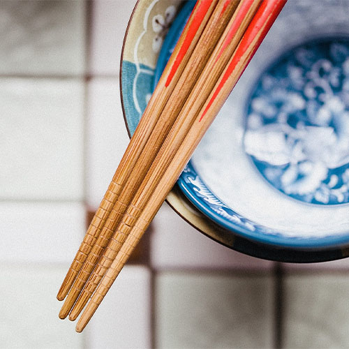 Chinesische Essstäbchen liegen auf einer Schüssel.