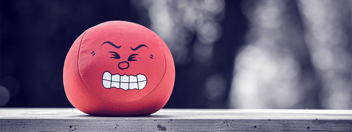 Ein roter Ball mit einem Gesicht darauf, das sich ärgert und wütend die Augen zusammenkneift.