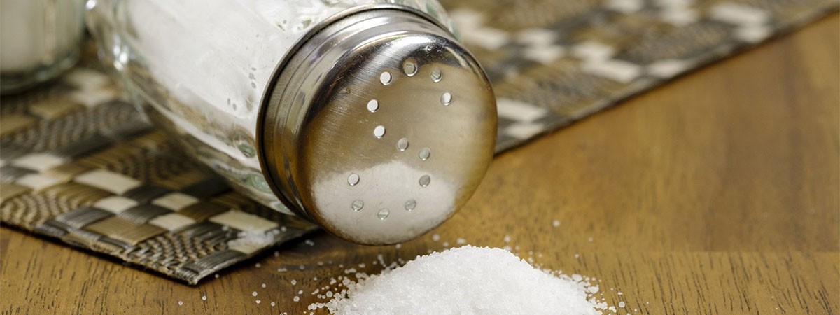 Ein Salzstreuer ist umgekippt, sodass das weiße Salz herausgerieselt ist.
