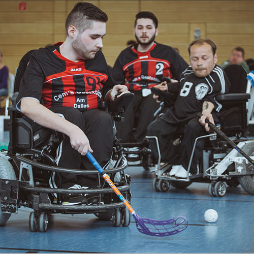 Von SMA-betroffenen Brüder David und Daniel (links) und Spieler Stefan (rechts) beim Powerchair-Hockey.