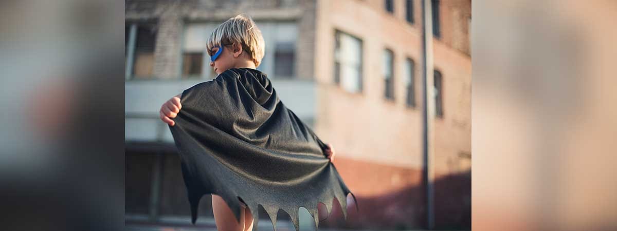 Ein Kind ist als Superheld verkleidet.