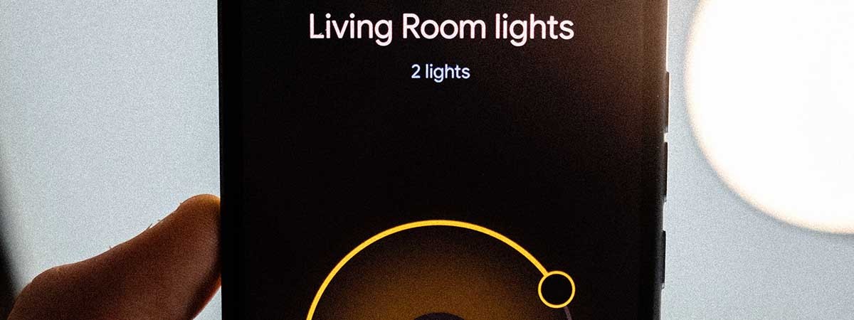 Ein Smartphone mit einer Smart-Home-App, die die Lichter der Wohnung steuert. Auf dem Display steht: Living Room lights, 2 lights, 70% Brightness, color.