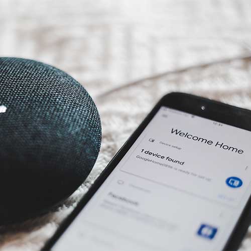 Ein Lautsprecher und ein Smartphone, auf dem steht: „Welcome Home, device found“.