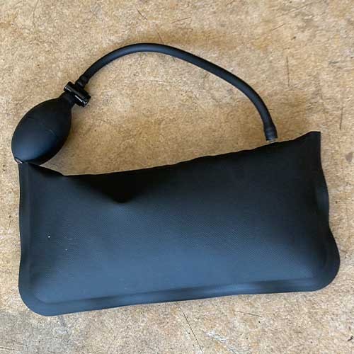 Ein schwarzes Hubkissen mit Handpumpe in Verwendung.