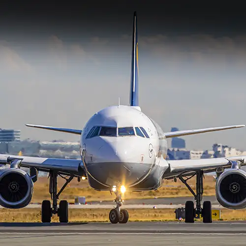 Foto von vorne auf ein Lufthansa Airbus Flugzeug, welches gerade auf einem Rollfeld steht. 