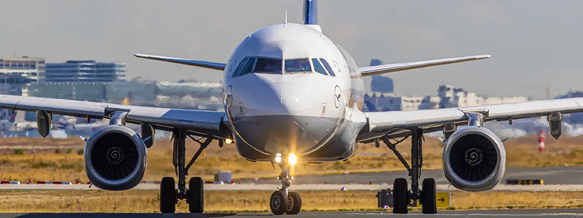 Foto von vorne auf ein Lufthansa Airbus Flugzeug, welches gerade auf einem Rollfeld steht. 