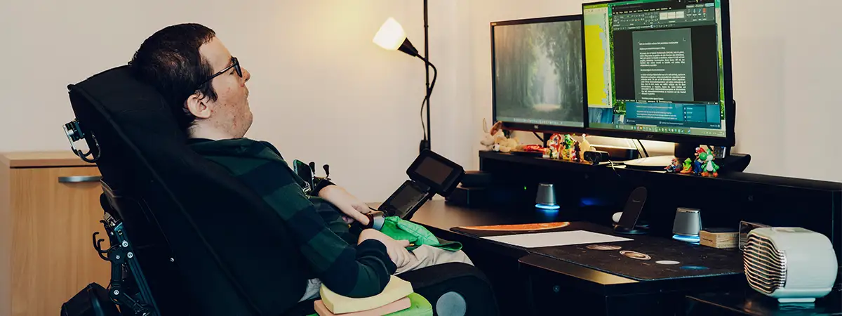 Ein Foto von Roberto, wie er an seinem Arbeitsplatz vor dem Computer sitzt und sich etwas durchliest.