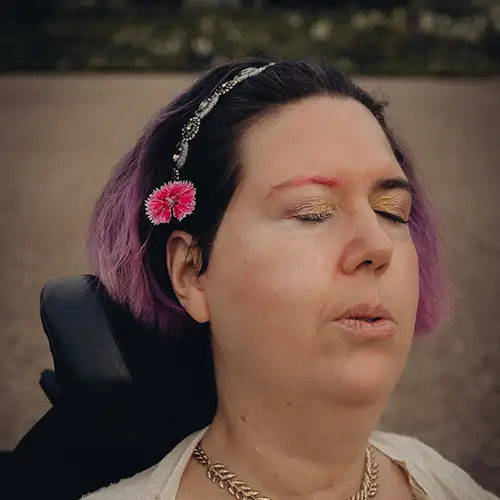 Ein Foto von Jasmin, wie sie die Augen schließt und tief ausatmet, während sie sich im Freien befindet.