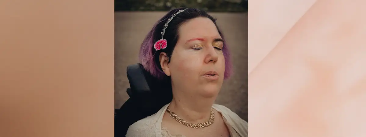 Ein Foto von Jasmin, wie sie die Augen schließt und tief ausatmet, während sie sich im Freien befindet.