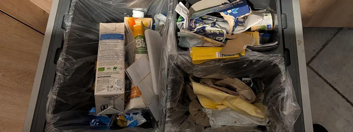 Ein Foto eines Mülleimers in einer Schublade mit separaten Fächern für Papier, Plastik und Restmüll.