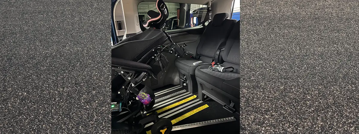 Ein Foto der Rückbank von Carolins umgebautem Auto mit ihrem leicht nach hinten geneigten Elektrorollstuhl.
