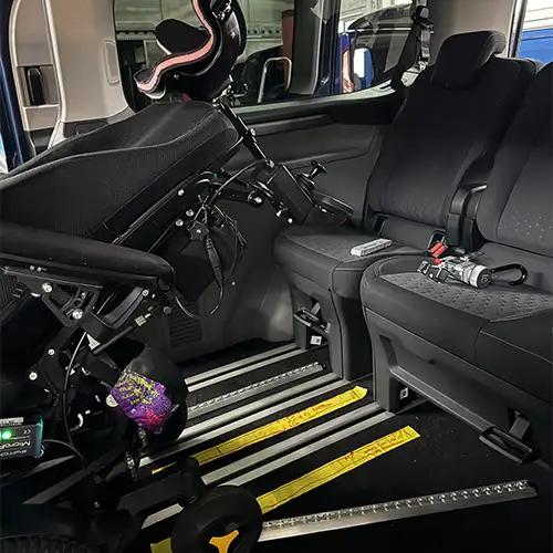 Ein Foto der Rückbank von Carolins umgebautem Auto mit ihrem leicht nach hinten geneigten Elektrorollstuhl.