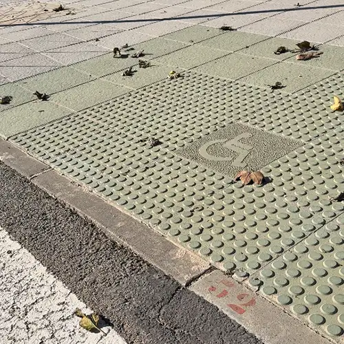 Ein Foto eines barrierefreien Stellplatzes mit festem Untergrund und einem Rollstuhl-Symbol.