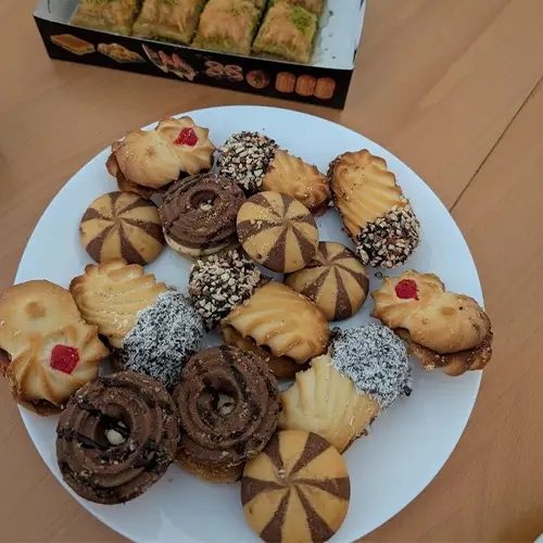 Ein Foto eines Tellers mit unterschiedlichen Keksen sowie einer Schachtel mit Baklava.