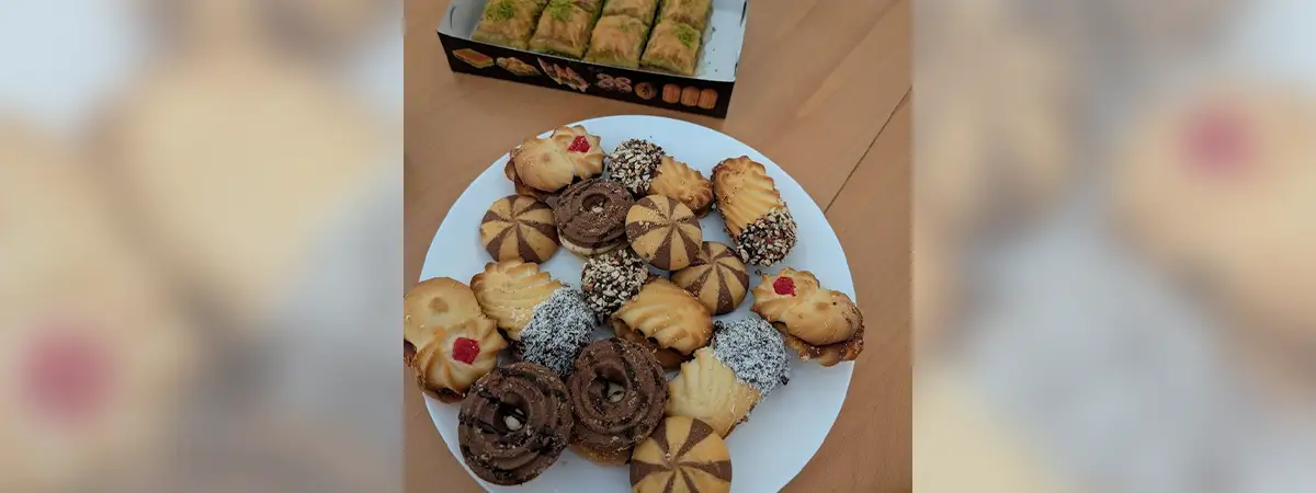Ein Foto eines Tellers mit unterschiedlichen Keksen sowie einer Schachtel mit Baklava.