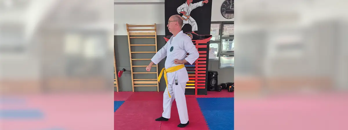 Ein Foto von Ulf, der seinen Karateanzug trägt und gerade die Technik „Gedan Barai“ von der Seite ausführt.
