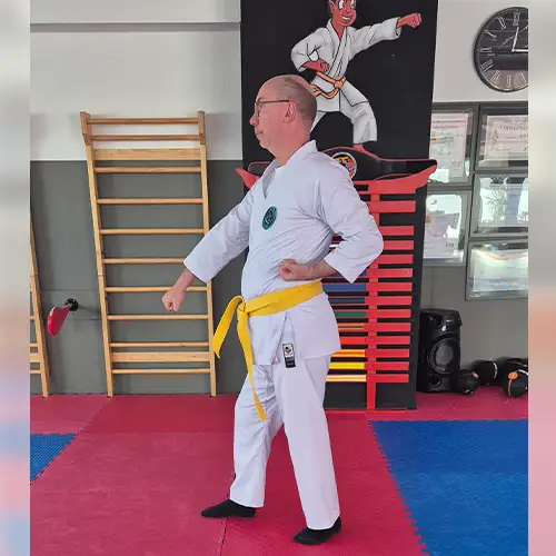 Ein Foto von Ulf, der seinen Karateanzug trägt und gerade die Technik „Gedan Barai“ von der Seite ausführt.