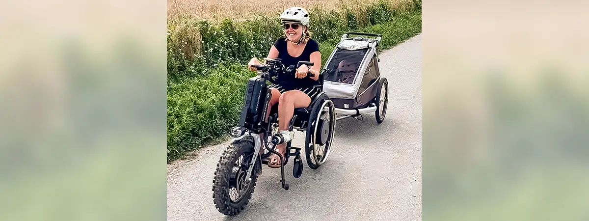 Svenja zieht den Fahrradanhänger, in dem ihre Tochter sitzt, mit dem Zuggerät 