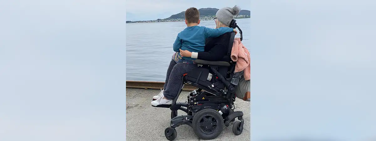 Ein Foto von Alina und ihrem Sohn, der auf ihrem Schoß sitzt – beide schauen zum Meer hinaus.