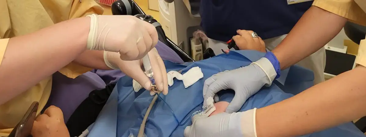 Ein Foto von Mediziner*innen, die gemeinsam einen Eingriff an Jasmin durchführen.