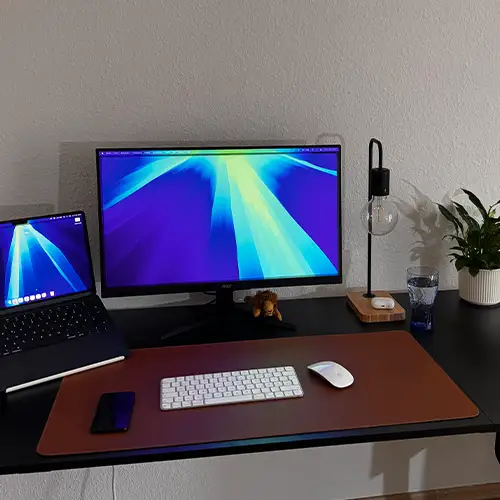 Remote-Work-Setup mit Laptop, Bildschirm und ergonomischem Arbeitsplatz im Homeoffice.