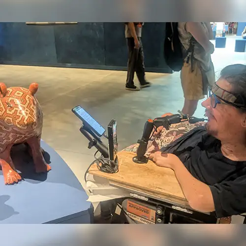 Christian im Elektrorollstuhl vor Kunst auf der Biennale in Venedig.