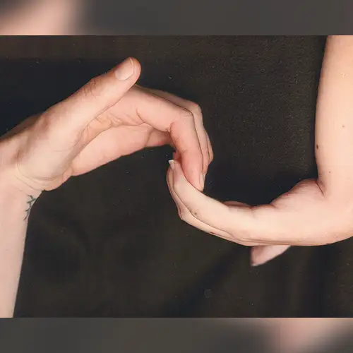 Zwei Hände, die sich an den Fingerspitzen berühren.