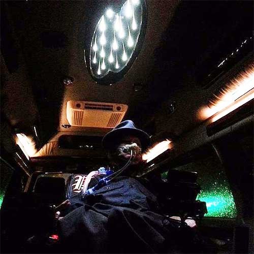 Phil sitzt im Dunklen in seinem Auto und wird von verschiedenen Lichtern etwas beleuchtet