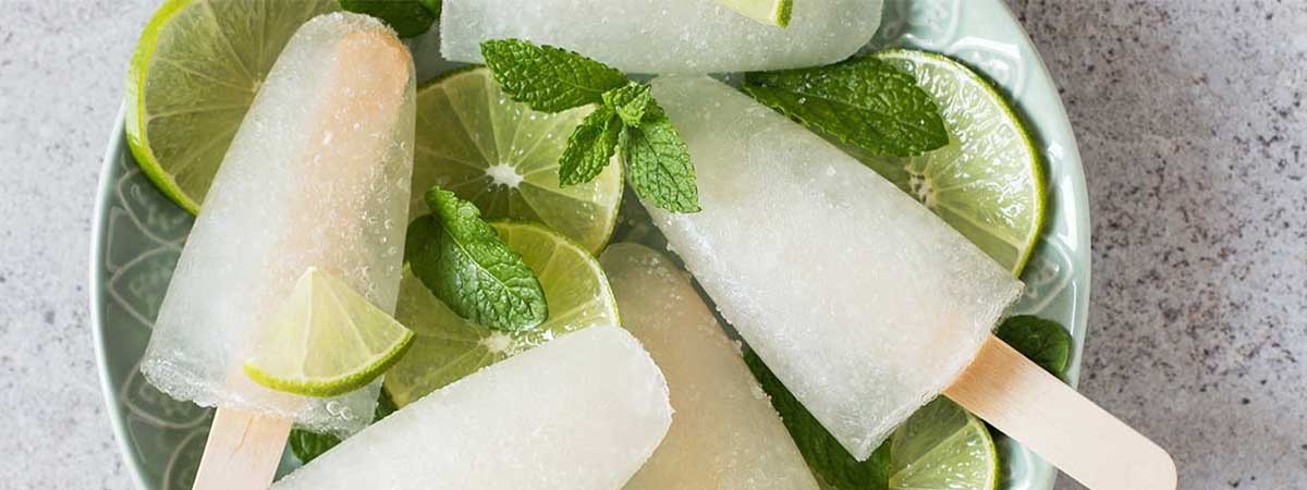 Wasserstieleis auf einem Teller mit Limette und Minze dekoriert.