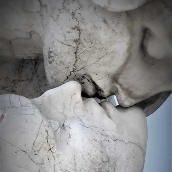 Zwei Steinfiguren küssen sich.