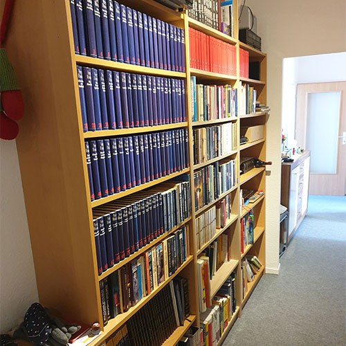 Holzregale im Flur sind befüllt mit einer privaten Bücher-Sammlung.