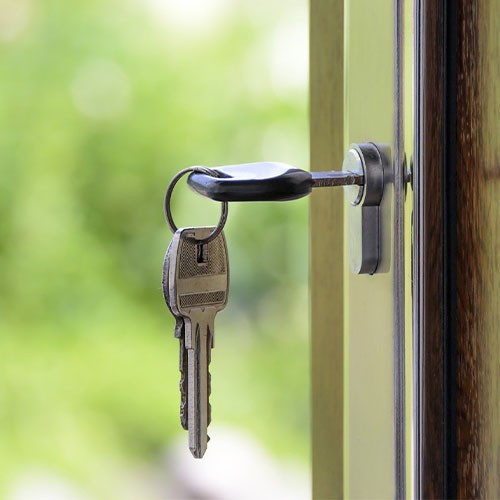 Ein Schlüssel steckt in einer offenen Haustür eines Zuhauses.