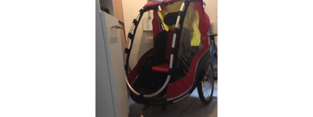 Ein Fahrradanhänger, mit dem der Vater seine Tochter transportieren kann. So kann die kleine SMA-Patientin bei Fahrradausflügen mit der Familie dabei sein.