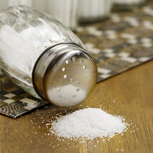 Ein Salzstreuer ist umgekippt, sodass das weiße Salz herausgerieselt ist.