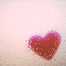 Bild von einem roten Herz hinter einer mit Wassertropfen beschlagenen Glasscheibe